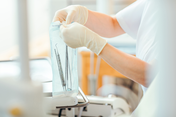 滅菌パックから歯科器具を取り出す歯科衛生士の手元